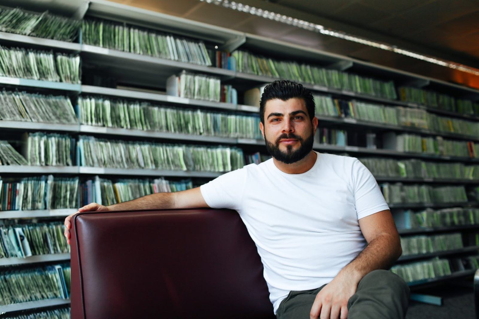 Kyriakos Gold seated in a library, looking at the camera